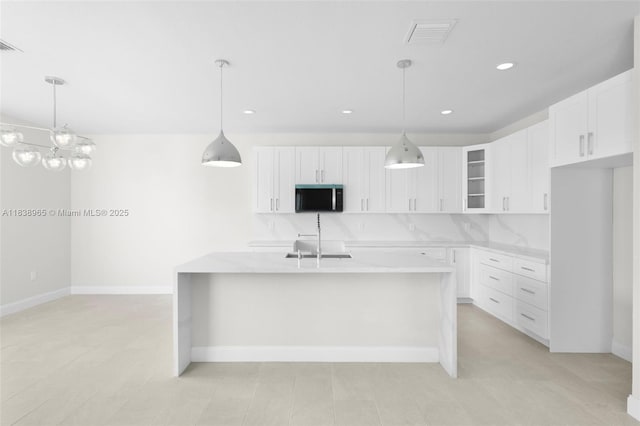 3451 SW 19th St, Fort Lauderdale, FL 33312 - kitchen with light countertops, white cabinets, recessed lighting, a kitchen island with sink, and glass insert cabinets
