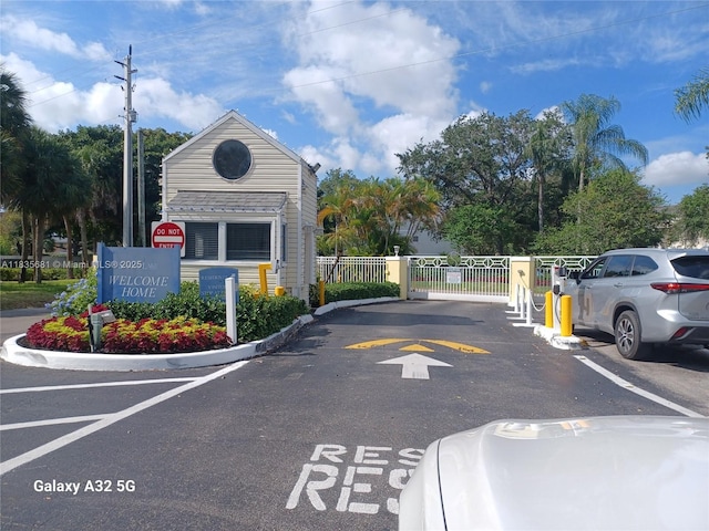 3421 NW 44th St Unit 103, Oakland Park, FL 33309 - view of asphalt street with a gate, curbs, and a gated entry