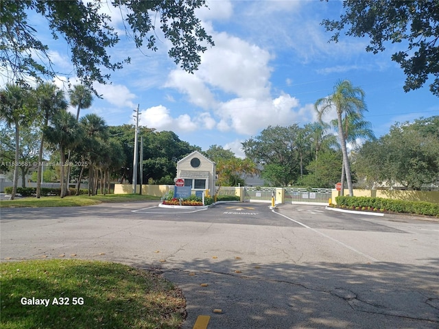 3421 NW 44th St Unit 103, Oakland Park, FL 33309 - view of asphalt street with traffic signs, a gated entry, and a gate