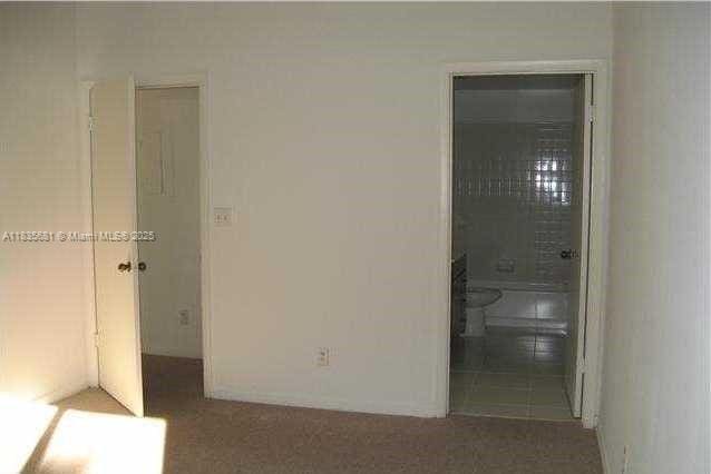 3421 NW 44th St Unit 103, Oakland Park, FL 33309 - unfurnished bedroom featuring ensuite bathroom