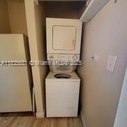 3421 NW 44th St Unit 103, Oakland Park, FL 33309 - laundry area with stacked washer / drying machine and light wood finished floors