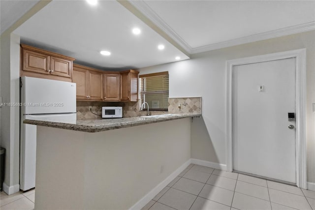 2400 NE 10th St Unit 104, Pompano Beach, FL 33062 - kitchen with white appliances, crown molding, decorative backsplash, recessed lighting, and light stone countertops