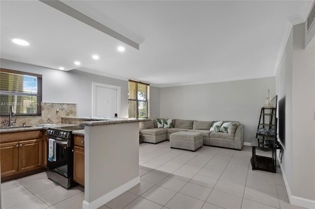 2400 NE 10th St Unit 104, Pompano Beach, FL 33062 - kitchen featuring electric range, brown cabinets, a peninsula, decorative backsplash, and light tile patterned flooring
