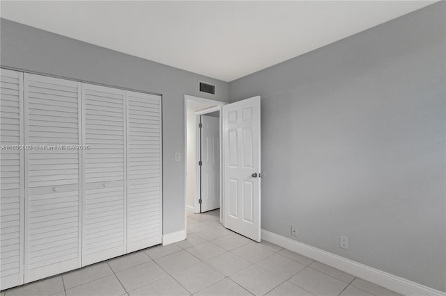 2400 NE 10th St Unit 104, Pompano Beach, FL 33062 - unfurnished bedroom featuring light tile patterned flooring and a closet