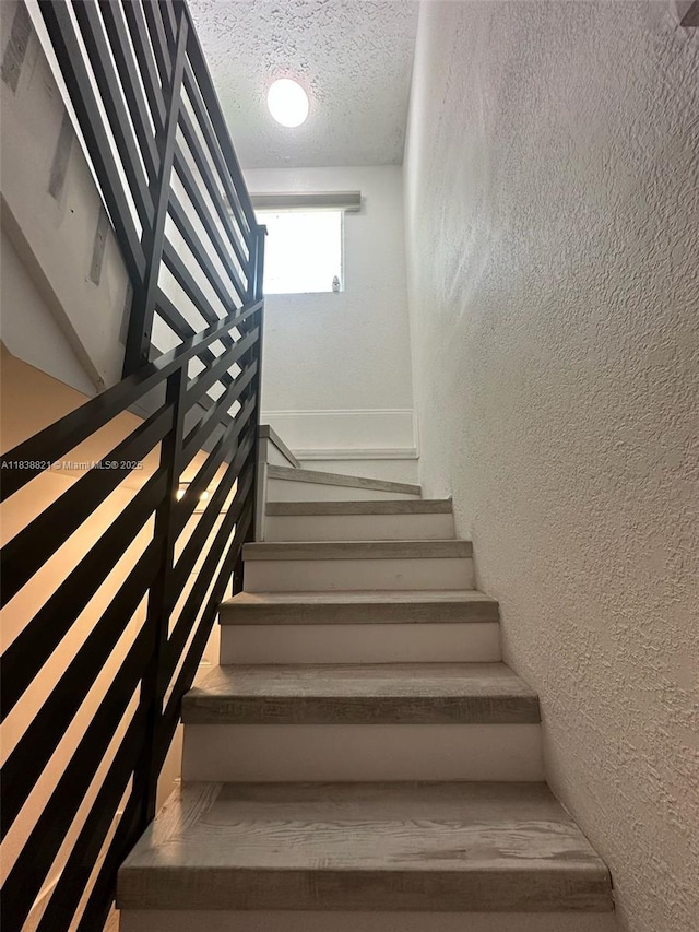 1249 S Flamingo Rd, Davie, FL 33325 - staircase with a textured ceiling and a textured wall
