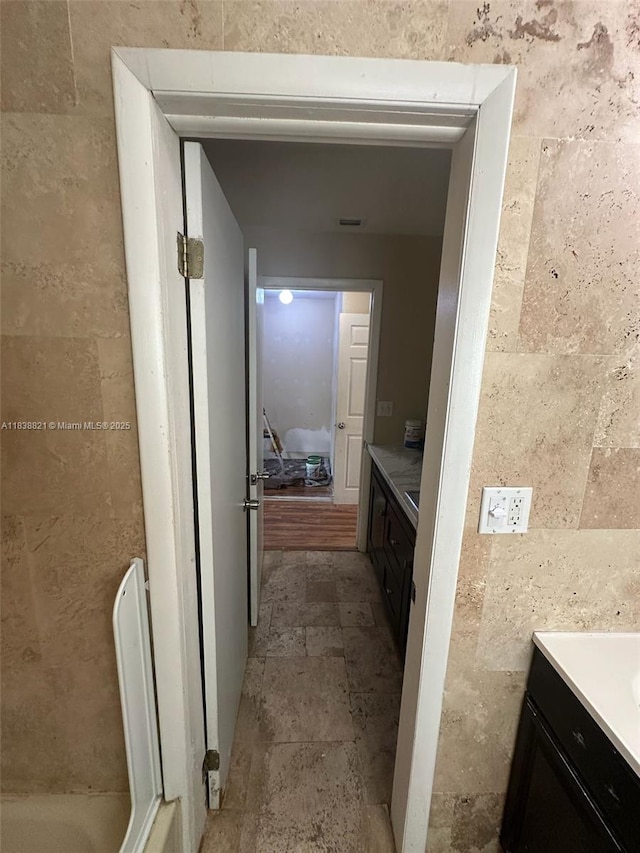 1249 S Flamingo Rd, Davie, FL 33325 - bathroom with vanity, tile walls, and stone finish flooring