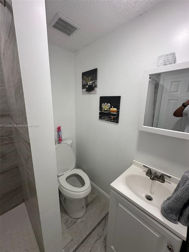 1249 S Flamingo Rd, Davie, FL 33325 - bathroom featuring a tile shower, vanity, a textured ceiling, and marble finish flooring