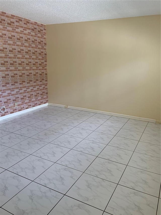 2405 Antigua Cir Unit H1, Coconut Creek, FL 33066 - empty room featuring a textured ceiling and brick wall