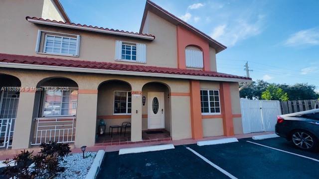 2385 W 69th St Unit 2385-B, Hialeah, FL 33016 - mediterranean / spanish-style home featuring covered porch, uncovered parking, stucco siding, and a gate