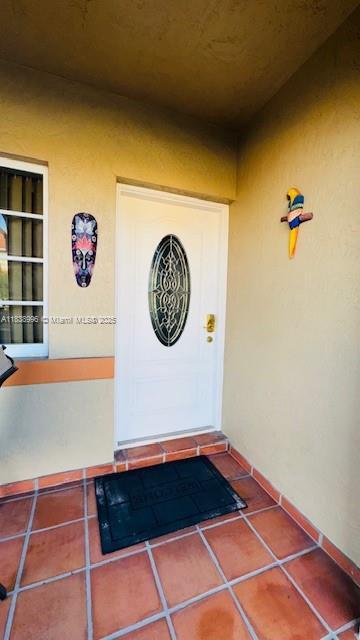 2385 W 69th St Unit 2385-B, Hialeah, FL 33016 - view of exterior entry with stucco siding and a porch