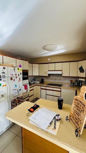 2385 W 69th St Unit 2385-B, Hialeah, FL 33016 - kitchen featuring white appliances, under cabinet range hood, light tile patterned floors, and light countertops
