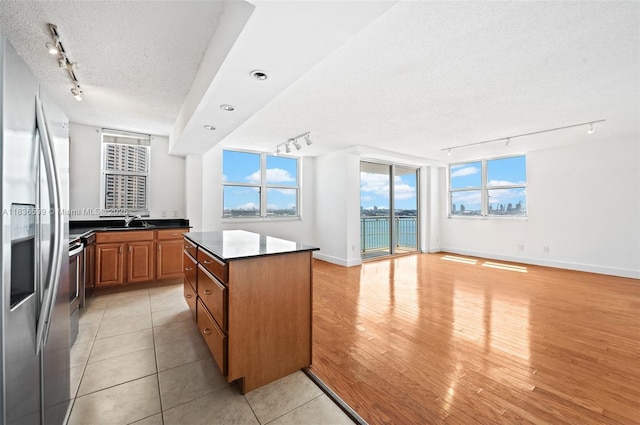 770 Claughton Island Dr Unit 1915, Miami, FL 33131 - kitchen featuring track lighting, stainless steel fridge, a textured ceiling, open floor plan, and a center island