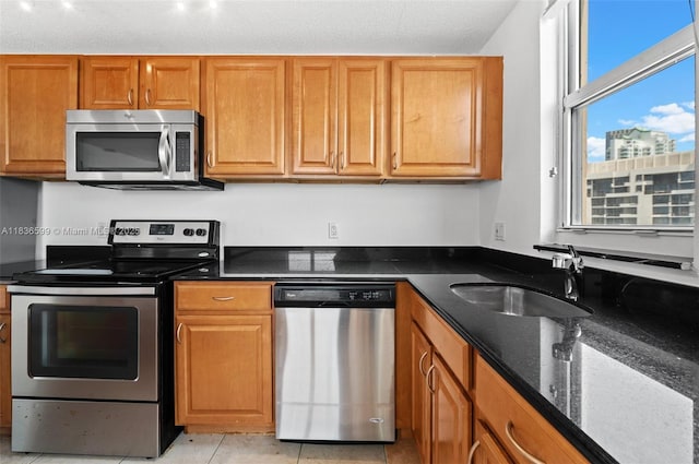 770 Claughton Island Dr Unit 1915, Miami, FL 33131 - kitchen featuring appliances with stainless steel finishes, brown cabinetry, dark stone counters, and light tile patterned floors