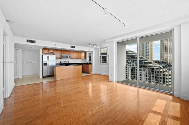 770 Claughton Island Dr Unit 1915, Miami, FL 33131 - unfurnished living room with rail lighting, light wood-style flooring, and a textured ceiling
