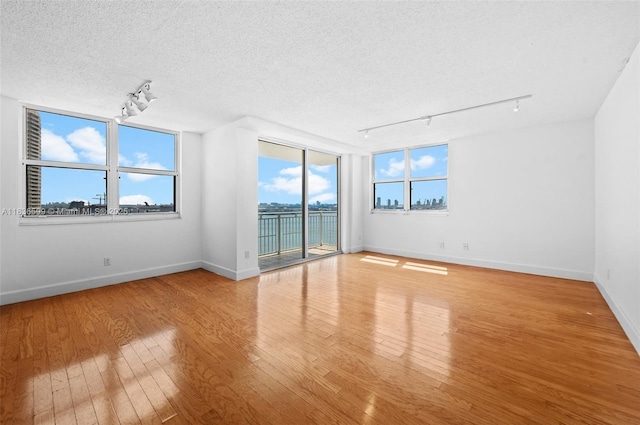 770 Claughton Island Dr Unit 1915, Miami, FL 33131 - spare room with rail lighting, wood finished floors, and a textured ceiling