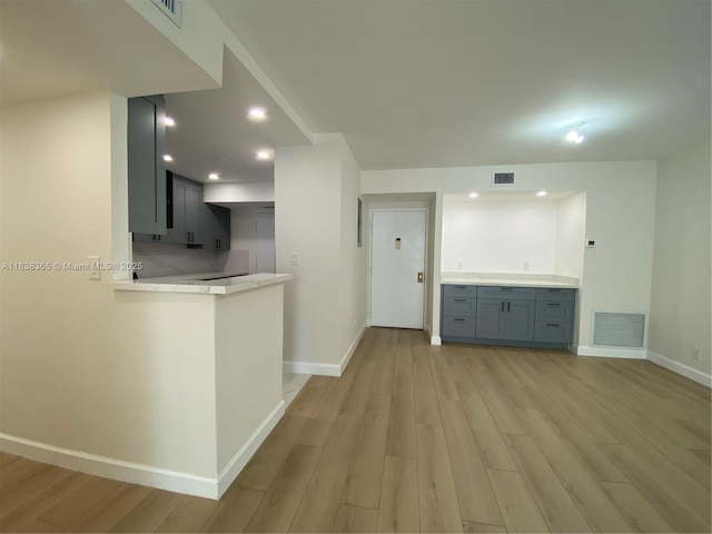 4400 Hillcrest Dr Unit 314B, Hollywood, FL 33021 - kitchen with light wood finished floors, light countertops, a peninsula, gray cabinetry, and recessed lighting