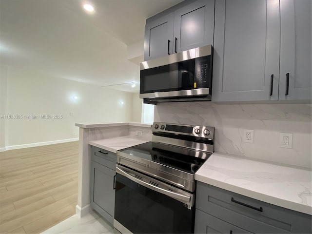 4400 Hillcrest Dr Unit 314B, Hollywood, FL 33021 - kitchen featuring stainless steel appliances, gray cabinetry, light stone counters, and backsplash