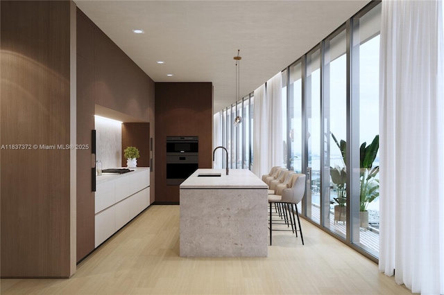 300 Biscayne Blvd Way Unit 4401, Miami, FL 33131 - kitchen featuring modern cabinets, floor to ceiling windows, black appliances, light countertops, and a kitchen island with sink