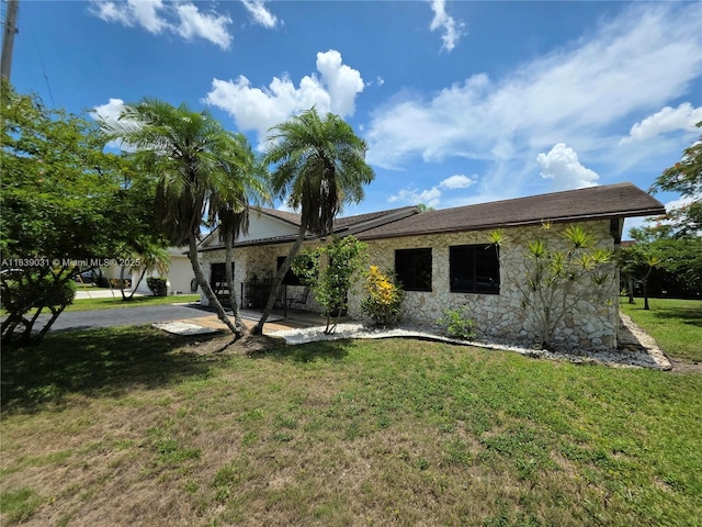 10120 NW 71st Pl, Tamarac, FL 33321 - view of front facade featuring stone siding, a front lawn, and a patio