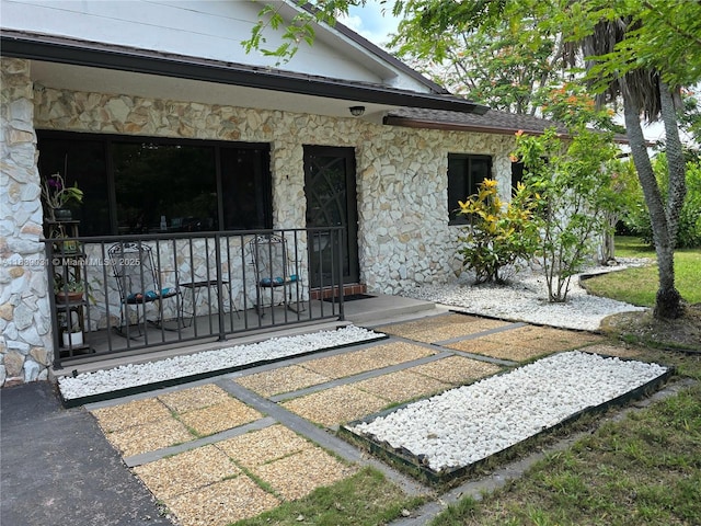10120 NW 71st Pl, Tamarac, FL 33321 - doorway to property featuring stone siding and a porch