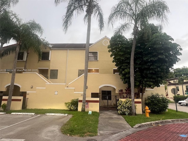 8831 SW 130th Pl Unit 106, Miami, FL 33186 - view of front of home with stucco siding, uncovered parking, and a gate