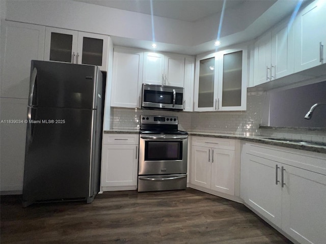8831 SW 130th Pl Unit 106, Miami, FL 33186 - kitchen with appliances with stainless steel finishes, white cabinets, light stone counters, dark wood-style floors, and glass insert cabinets