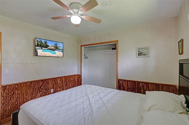 16000 N Miami Ave, Miami, FL 33169 - bedroom featuring wainscoting, wooden walls, a ceiling fan, and a closet
