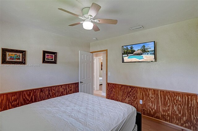 16000 N Miami Ave, Miami, FL 33169 - bedroom featuring wainscoting, ceiling fan, wooden walls, and wood finished floors