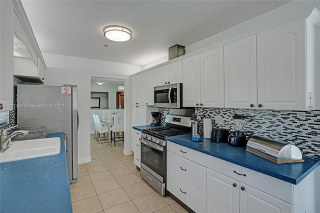 16000 N Miami Ave, Miami, FL 33169 - kitchen with stainless steel appliances, dark countertops, white cabinetry, and light tile patterned floors