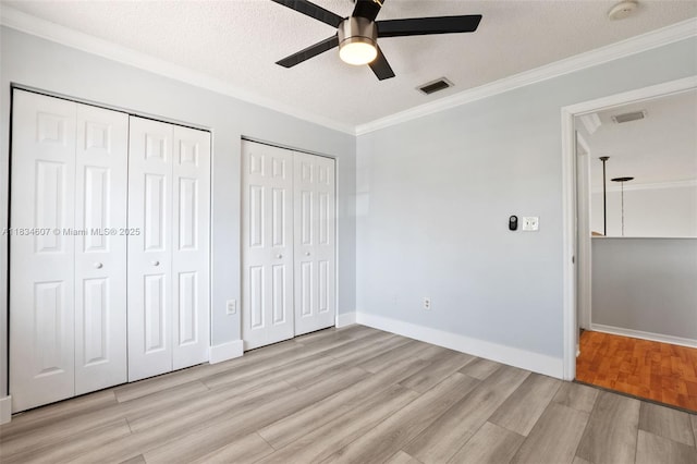 14834 SW 140th St, Miami, FL 33196 - unfurnished bedroom with multiple closets, light wood finished floors, ornamental molding, a textured ceiling, and a ceiling fan