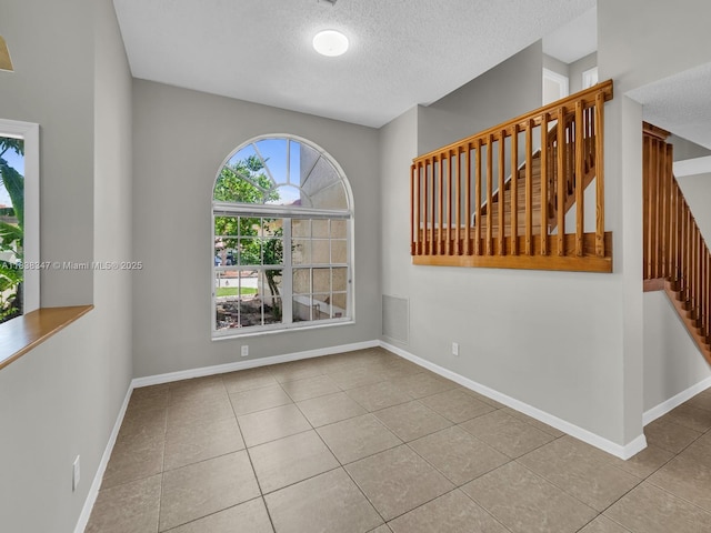18232 SW 5th St, Pembroke Pines, FL 33029 - tiled empty room with stairway and a textured ceiling