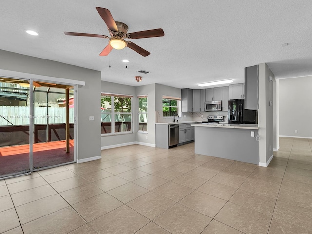 18232 SW 5th St, Pembroke Pines, FL 33029 - kitchen with stainless steel appliances, gray cabinetry, light countertops, light tile patterned flooring, and a ceiling fan