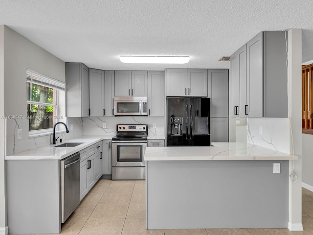 18232 SW 5th St, Pembroke Pines, FL 33029 - kitchen featuring stainless steel appliances, gray cabinets, a peninsula, a textured ceiling, and light tile patterned floors