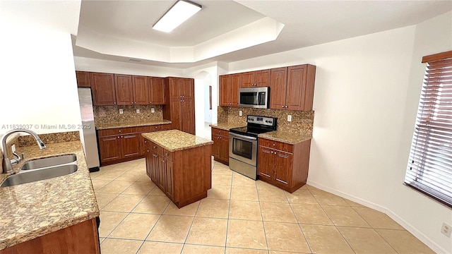 3001 SW 156th Ave, Miami, FL 33185 - kitchen with stainless steel appliances, a tray ceiling, tasteful backsplash, a kitchen island, and light tile patterned flooring