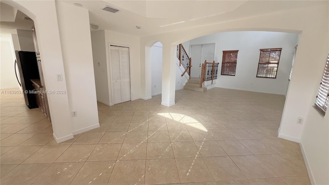 3001 SW 156th Ave, Miami, FL 33185 - unfurnished room featuring light tile patterned floors, arched walkways, and stairs