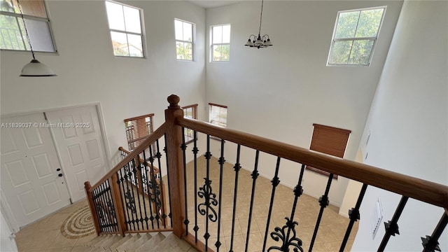 3001 SW 156th Ave, Miami, FL 33185 - stairway with tile patterned flooring, plenty of natural light, a chandelier, and a towering ceiling