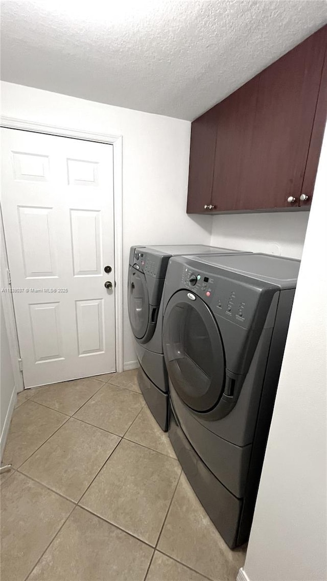 3001 SW 156th Ave, Miami, FL 33185 - laundry room featuring washing machine and dryer, cabinet space, light tile patterned floors, and a textured ceiling