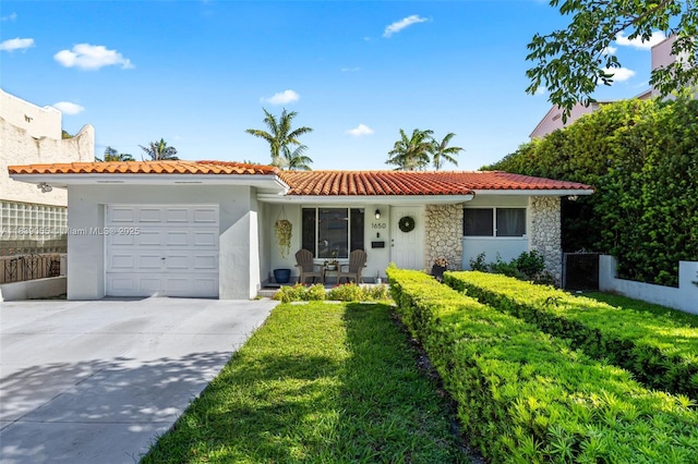 1650 SW 17th St, Miami, FL 33145 - view of front facade with a tiled roof, a porch, a garage, concrete driveway, and stone siding