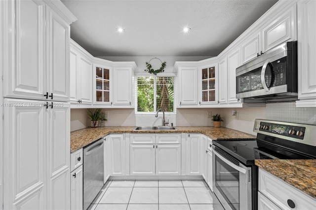 1650 SW 17th St, Miami, FL 33145 - kitchen featuring appliances with stainless steel finishes, white cabinets, light tile patterned floors, decorative backsplash, and recessed lighting