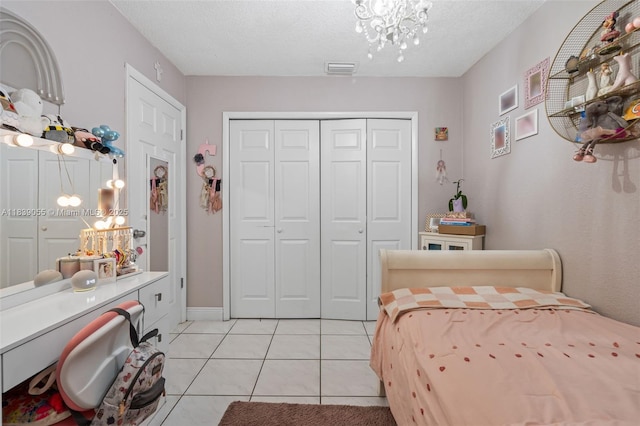 1650 SW 17th St, Miami, FL 33145 - bedroom featuring light tile patterned floors, a closet, a chandelier, and a textured ceiling