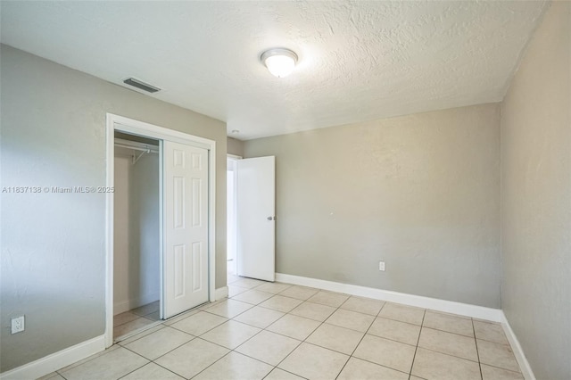 8390 NW 24th St, Sunrise, FL 33322 - unfurnished bedroom with a closet, light tile patterned flooring, and a textured ceiling