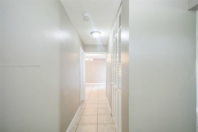 8390 NW 24th St, Sunrise, FL 33322 - hallway featuring a textured ceiling, light tile patterned flooring, and a chandelier