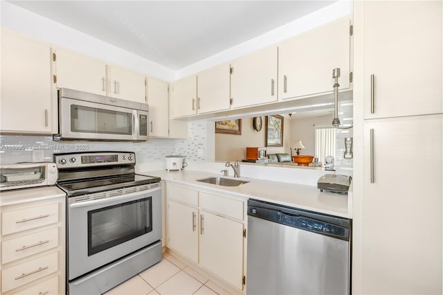 5560 Lakeside Dr Unit 204, Margate, FL 33063 - kitchen with stainless steel appliances, light countertops, decorative backsplash, and light tile patterned floors