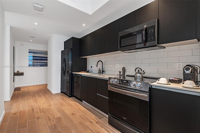 398 NE 5th St Unit 3711, Miami, FL 33132 - kitchen with stainless steel appliances, dark cabinetry, light countertops, light wood-style flooring, and tasteful backsplash