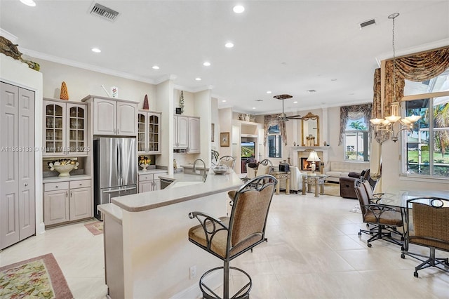 15595 Chandelle Pl, Wellington, FL 33414 - kitchen featuring freestanding refrigerator, a breakfast bar area, recessed lighting, crown molding, and light countertops