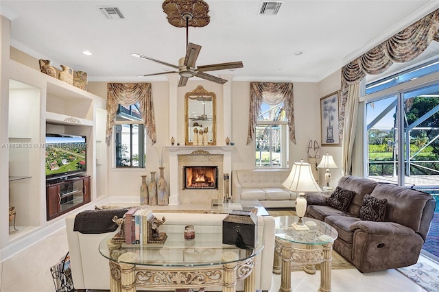 15595 Chandelle Pl, Wellington, FL 33414 - living area with ornamental molding, healthy amount of natural light, a lit fireplace, tile patterned flooring, and a ceiling fan