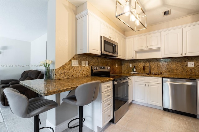 8010 SW 18th Ct Unit 1-8, Davie, FL 33324 - kitchen featuring stainless steel appliances, decorative backsplash, white cabinetry, and a kitchen breakfast bar