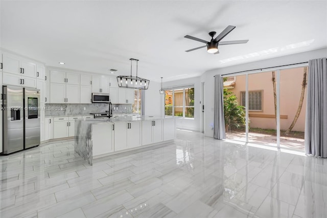5050 Greenwich Preserve Ct, Boynton Beach, FL 33436 - kitchen featuring stainless steel appliances, light countertops, white cabinetry, a ceiling fan, and tasteful backsplash