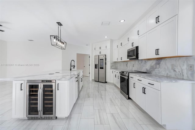 5050 Greenwich Preserve Ct, Boynton Beach, FL 33436 - kitchen with beverage cooler, stainless steel appliances, white cabinetry, light stone counters, and decorative backsplash
