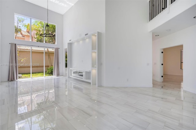 5050 Greenwich Preserve Ct, Boynton Beach, FL 33436 - unfurnished living room with a towering ceiling, a chandelier, and marble finish flooring